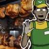 Fresh food worker holding hands up in front of rotisserie oven with chickens cooking in it